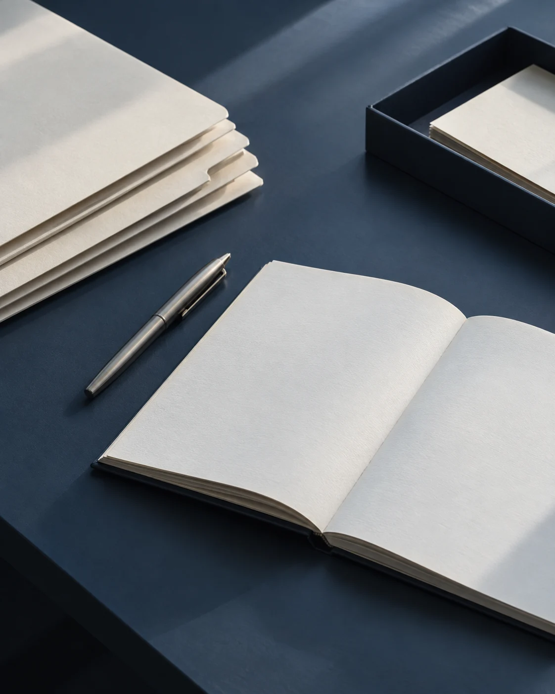 Dossiers et carnet organisés sur un bureau bleu ardoise